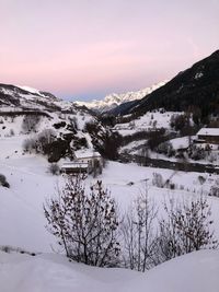 Scenic view of snow covered mountains against sky at sunset