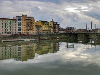 Reflection of buildings in river against sky