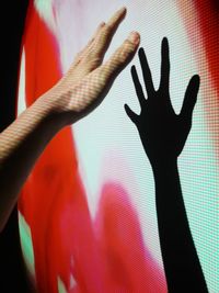 Cropped hand of person with shadow on projector