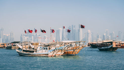 Boats on sea against buildings in city