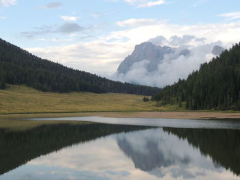 Scenic view of lake by mountains against sky