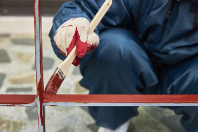 Midsection of person working on red grill