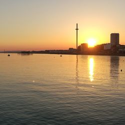 View of city at waterfront during sunset