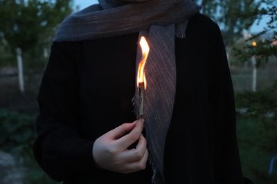 Close-up of woman holding burning stick