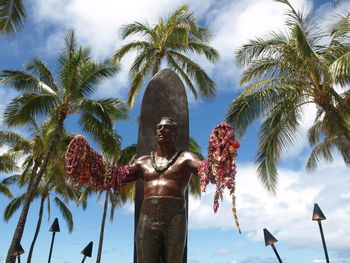 Low angle view of man statue against trees