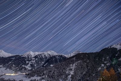 Scenic view of snowcapped mountains against sky at night