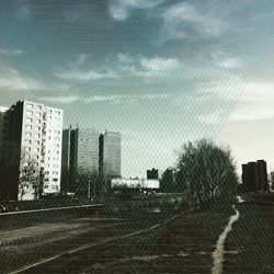 Buildings in city against cloudy sky