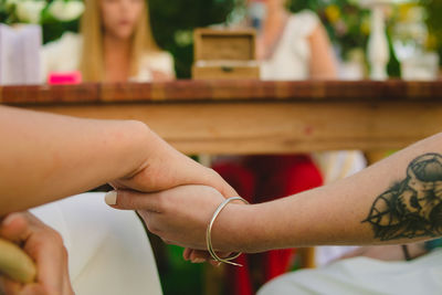 Midsection of couple holding hands