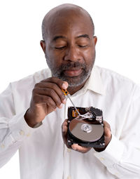 Portrait of man holding camera over white background