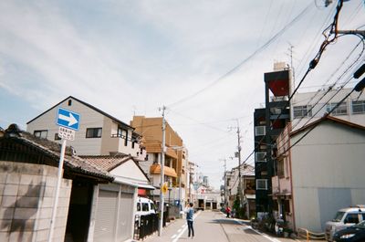 Road amidst buildings in city against sky