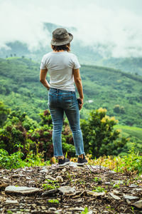 Rear view of woman walking on field