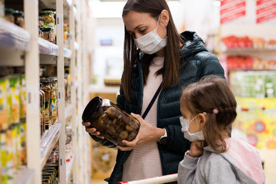 Mother and daughter wearing mask at supermarket