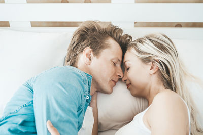 Couple cuddling on bed in home