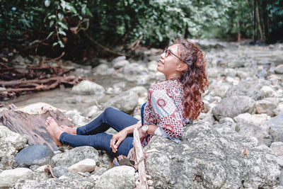 Young woman sitting on rock