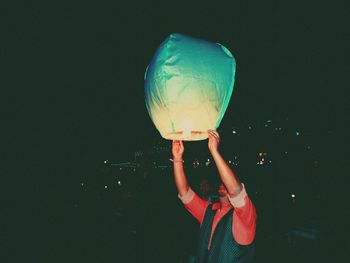 Man releasing pape0r lantern during night