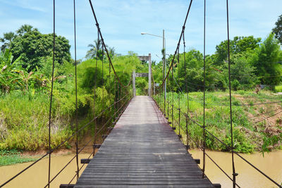 Suspension bridge in the forest with blue sky background