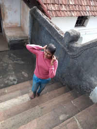 Full length of woman standing by stone wall