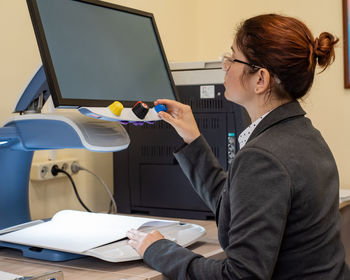 Side view of woman using computer equipment