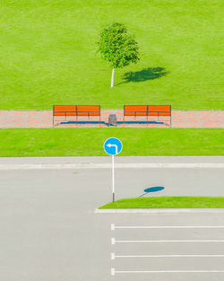 Information sign on empty road against grassy field