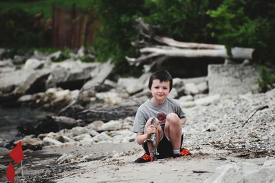 Portrait of boy sitting on land