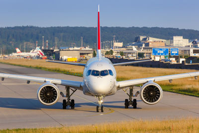 View of airplane at airport runway against sky