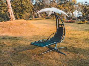 Empty chair on field in park