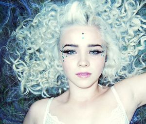 High angle portrait of young woman lying on bed