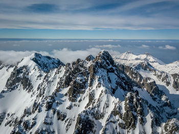 Scenic view of snowcapped mountains against cloudy sky