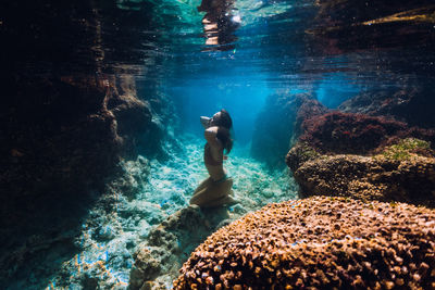 Low section of man swimming in sea