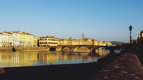 Arch bridge over river against blue sky