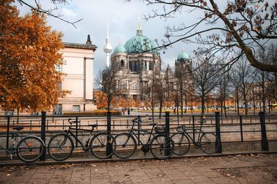 Bicycle parked by building during autumn