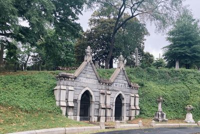 View of cemetery against trees and building