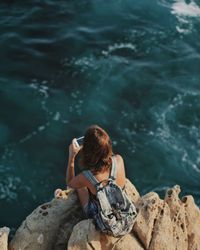 Woman sitting on rock by river