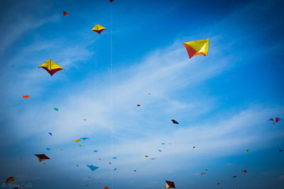 Low angle view of kites flying in sky