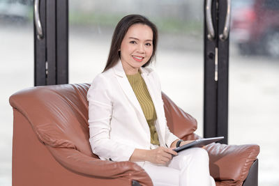 Portrait of a smiling young woman using smart phone