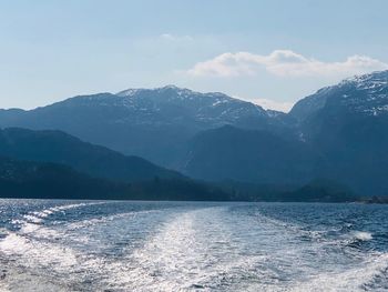 Scenic view of sea and mountains against sky