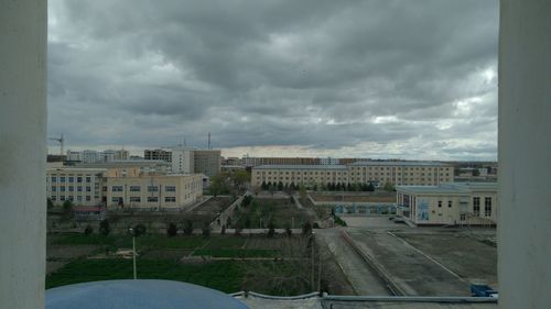 Buildings against sky seen through glass window