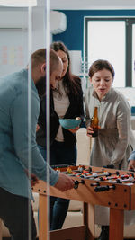 Business colleagues playing foosball at office