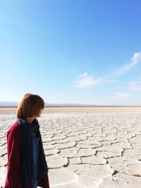 Woman standing against blue sky at desert