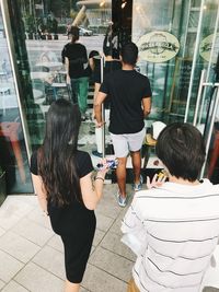 Rear view of people standing in city