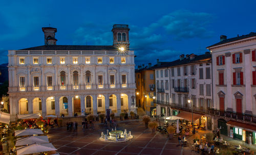 Group of people on street against buildings at night