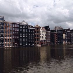 Buildings in city against cloudy sky