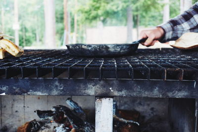 Close-up of hand on barbecue grill