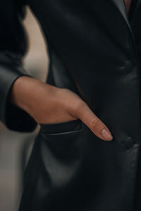 Female hand in the pocket. fashion details of a black leather jacket. fancy outfit