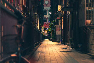 Illuminated alley amidst buildings at night