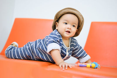 Cute baby boy lying on sofa at home