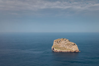 Rocks in sea against sky