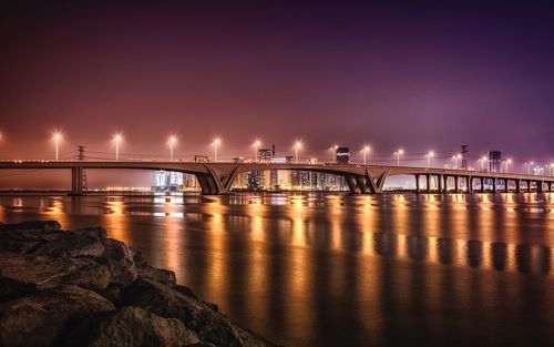 Bridge over sea against sky at night