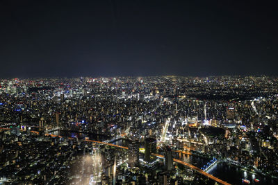 High angle view of illuminated city against sky at night