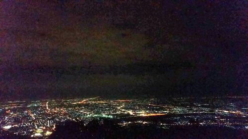 Illuminated city against sky at night